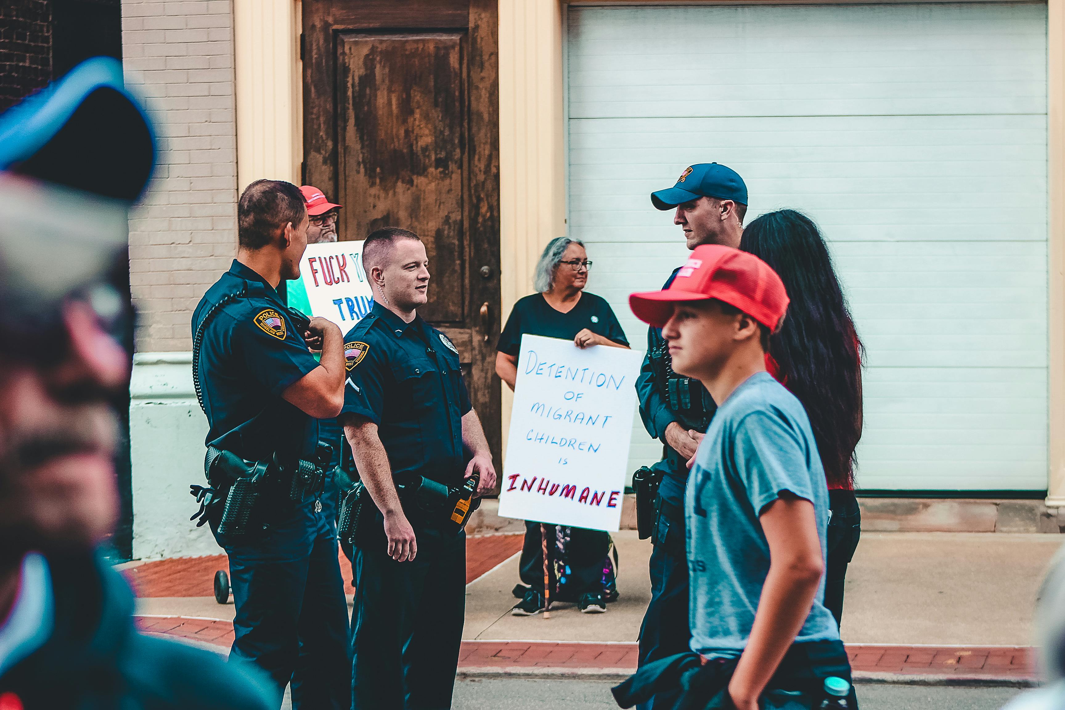 Photo by Rosemary Ketchum: https://www.pexels.com/photo/police-standing-near-woman-and-man-holding-up-signage-1464208/